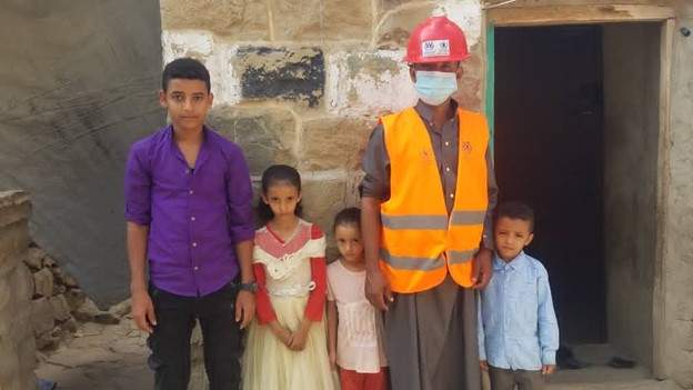 The Beneficiary Abdu Mahdi As-Salehi and his kids Wearing the Safety Tools and Standing up in Front of his Home in Tabih village from Bani Saleh sub-district of Wusab As-Safil district in Dhamar Governorate 